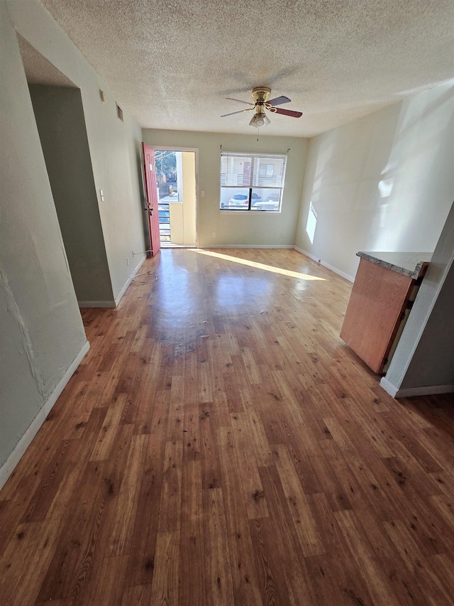 unfurnished living room featuring hardwood / wood-style flooring, a textured ceiling, and ceiling fan