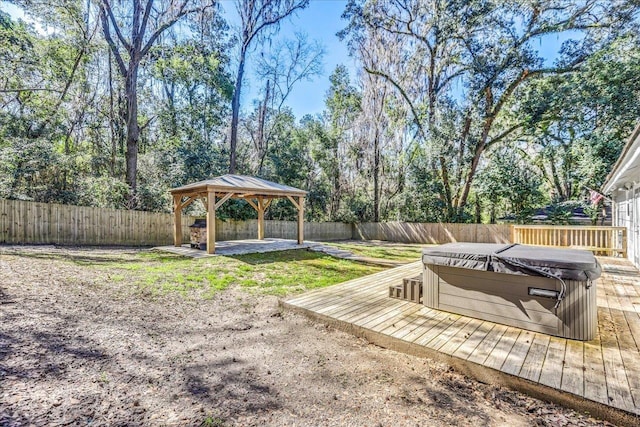 view of yard featuring a hot tub, a deck, a fenced backyard, and a gazebo