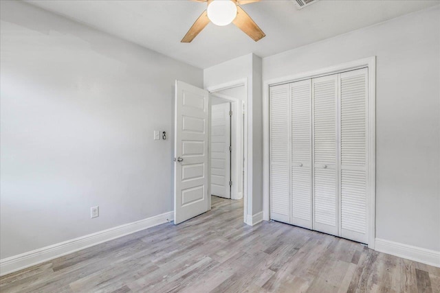 unfurnished bedroom with visible vents, baseboards, a ceiling fan, wood finished floors, and a closet