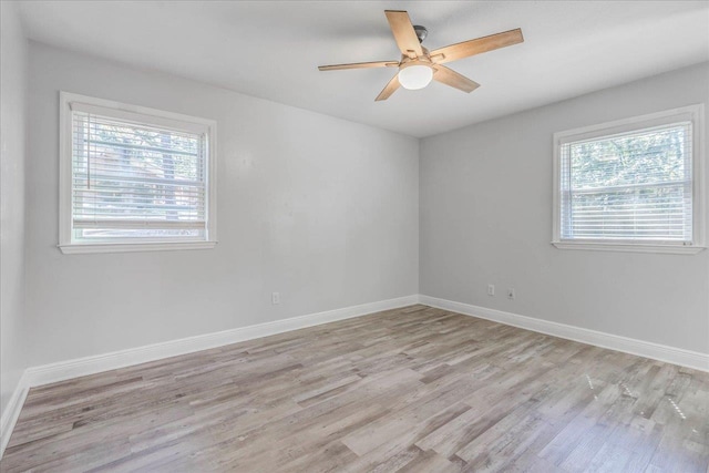 unfurnished room featuring light wood-type flooring, baseboards, and a wealth of natural light