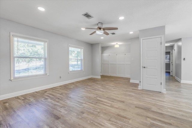 empty room featuring light wood finished floors, recessed lighting, visible vents, and baseboards