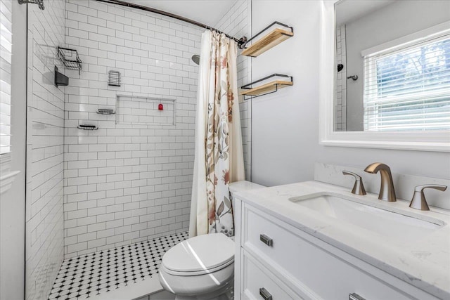 bathroom with a shower stall, toilet, and vanity