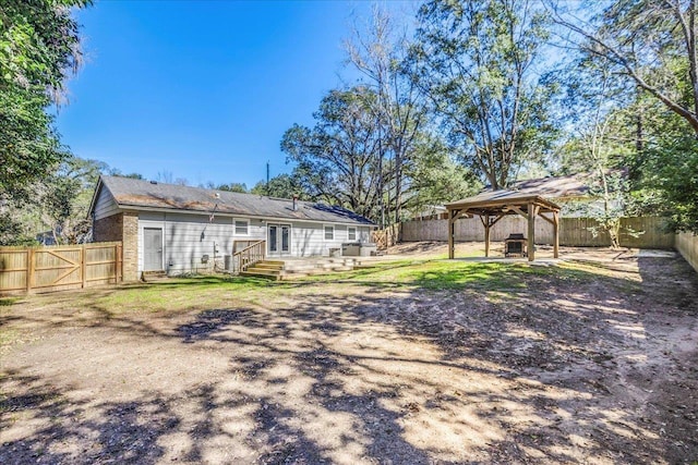 rear view of house featuring entry steps, a gazebo, a patio, and a fenced backyard