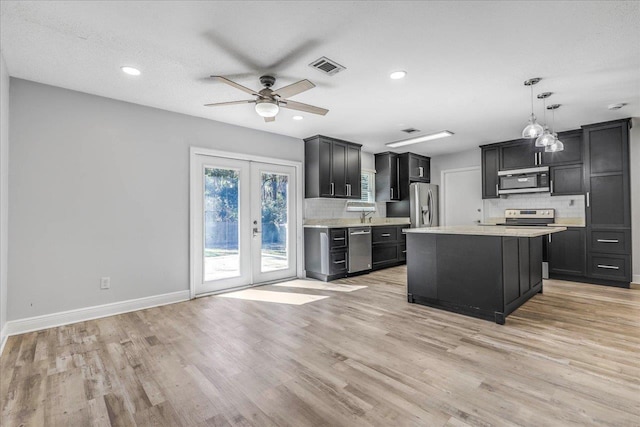 kitchen featuring stainless steel appliances, visible vents, light countertops, french doors, and dark cabinetry