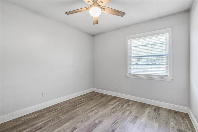 empty room featuring ceiling fan, wood finished floors, and baseboards