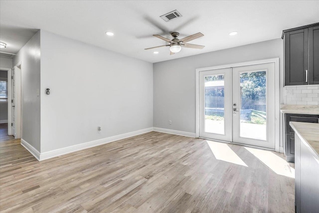 unfurnished living room featuring french doors, visible vents, light wood-style flooring, and baseboards