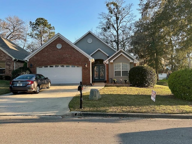 ranch-style house with a front yard, an attached garage, stucco siding, concrete driveway, and french doors