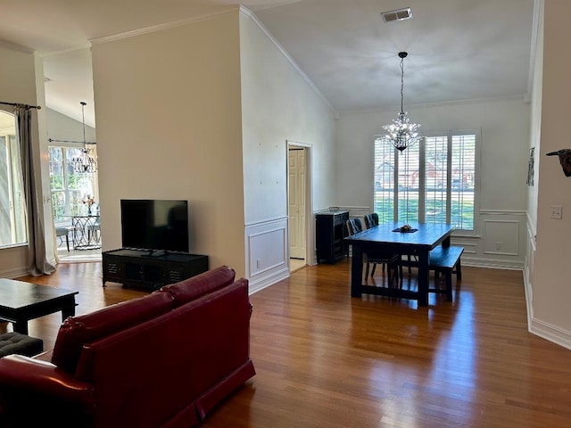 living room with visible vents, an inviting chandelier, crown molding, and vaulted ceiling