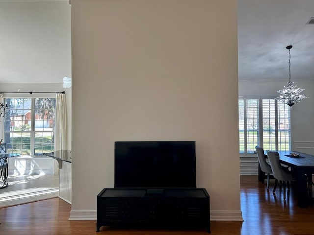 interior space featuring a wealth of natural light, a notable chandelier, and wood finished floors