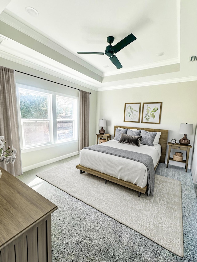 carpeted bedroom with a raised ceiling, ceiling fan, and crown molding