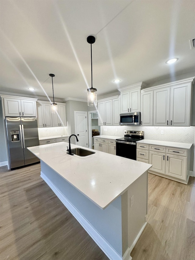 kitchen with sink, white cabinets, stainless steel appliances, and decorative light fixtures