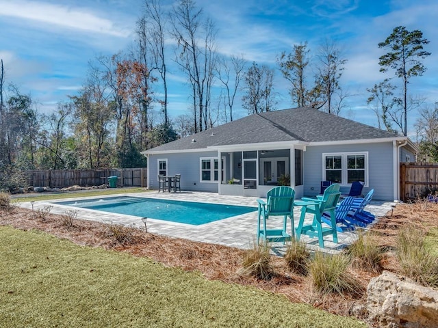 view of swimming pool with a patio, a sunroom, and a lawn