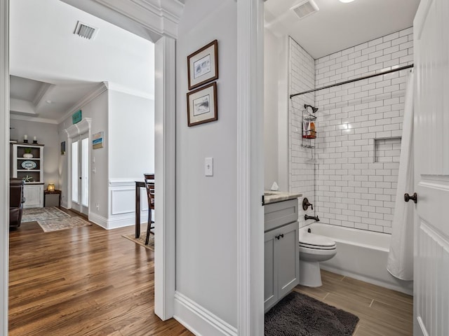 full bathroom featuring shower / tub combo with curtain, hardwood / wood-style flooring, vanity, ornamental molding, and toilet