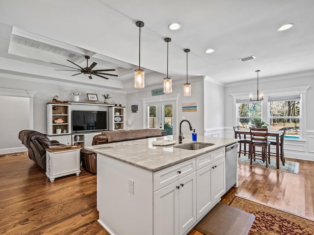 kitchen featuring light stone counters, white cabinetry, sink, and pendant lighting