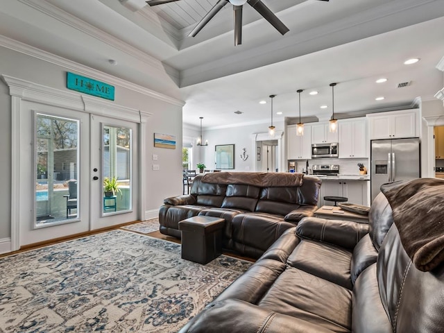 living room with crown molding, ceiling fan, a tray ceiling, wood-type flooring, and french doors