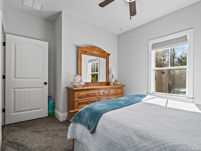 carpeted bedroom featuring multiple windows and ceiling fan