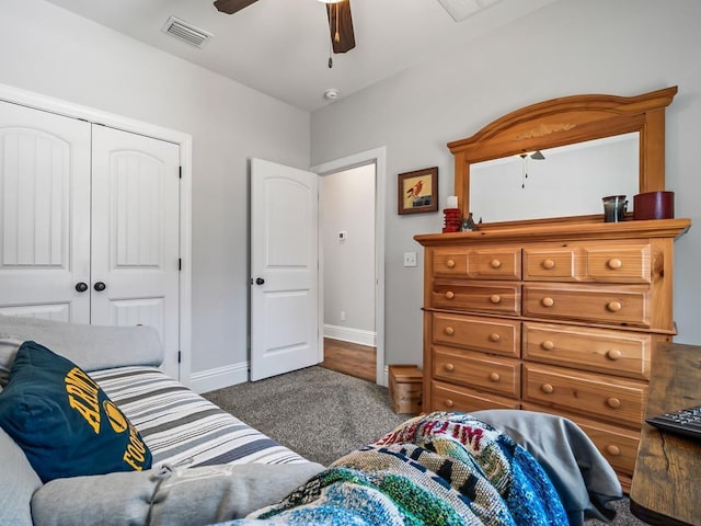 bedroom featuring dark colored carpet, ceiling fan, and a closet