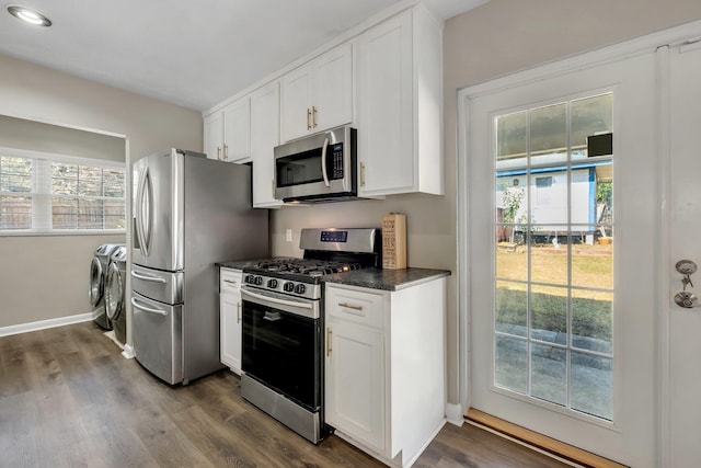 kitchen featuring stainless steel appliances, white cabinetry, baseboards, dark wood-style floors, and washing machine and clothes dryer