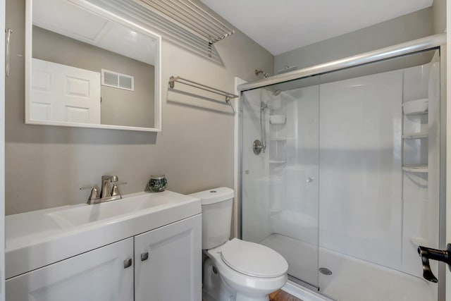 bathroom featuring toilet, visible vents, a stall shower, and vanity