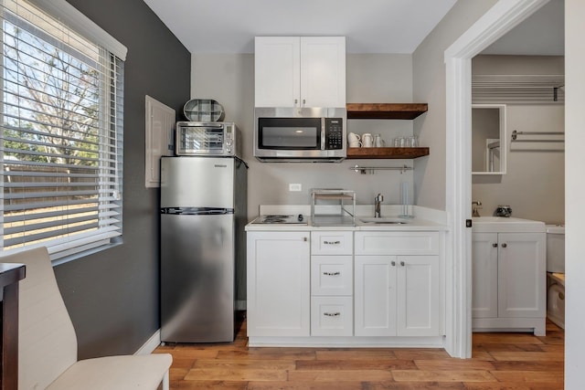 2214 Oxford Rd, Tallahassee, FL 32304 - kitchen featuring light countertops, a sink, open shelves, stainless steel appliances, and white cabinets