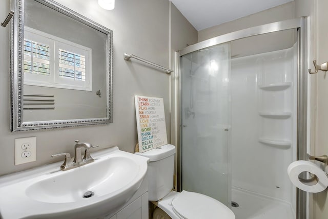 bathroom featuring toilet, a stall shower, and vanity