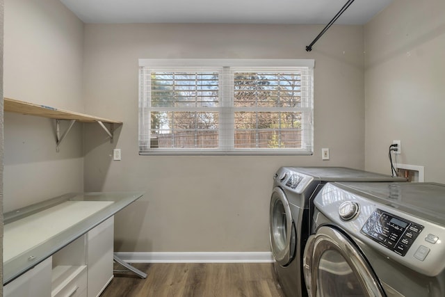 laundry area featuring laundry area, baseboards, dark wood finished floors, and washing machine and clothes dryer