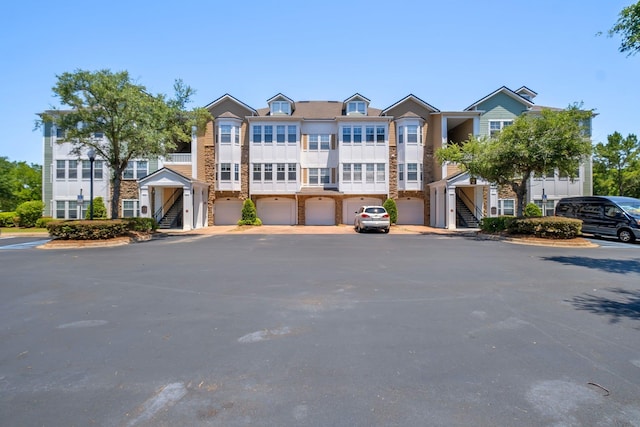 2801 Chancellorsville Dr Unit 236, Tallahassee, FL 32312 - view of property with stairway, stone siding, and uncovered parking