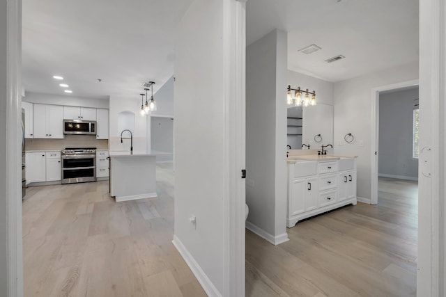 2801 Chancellorsville Dr Unit 236, Tallahassee, FL 32312 - corridor featuring light wood-style flooring, baseboards, a sink, and recessed lighting