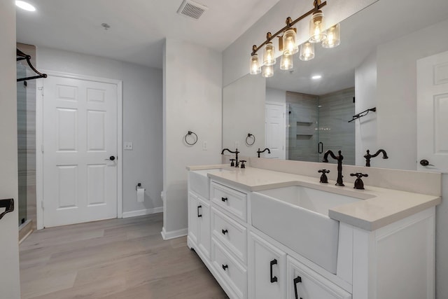 2801 Chancellorsville Dr Unit 236, Tallahassee, FL 32312 - bathroom with a stall shower, double vanity, wood finished floors, baseboards, and recessed lighting