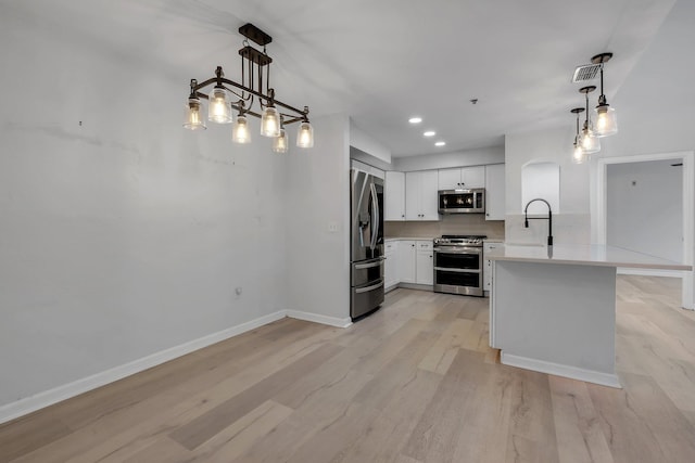 2801 Chancellorsville Dr Unit 236, Tallahassee, FL 32312 - kitchen with stainless steel appliances, a peninsula, light countertops, light wood finished floors, and arched walkways