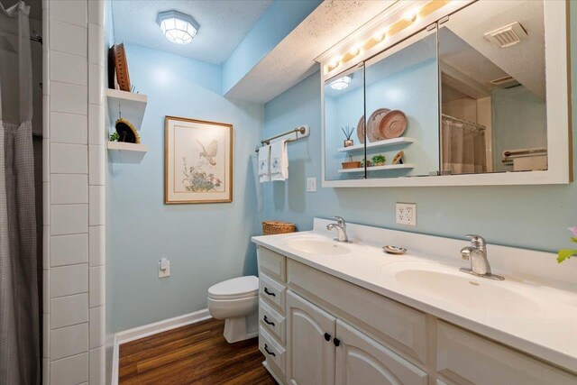 40 Carrol Dr, Crawfordville, FL 32327 - bathroom featuring toilet, wood finished floors, baseboards, double vanity, and curtained shower