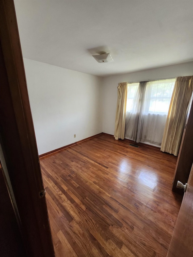 512 Hampton Ave, Tallahassee, FL 32310 - spare room featuring baseboards, dark wood finished floors, and visible vents