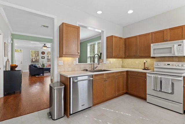 kitchen with sink, decorative backsplash, ceiling fan, crown molding, and white appliances