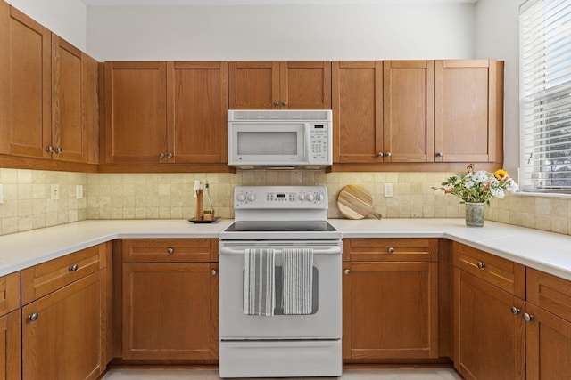 kitchen with tasteful backsplash and white appliances