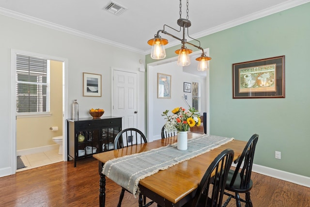 dining room with ornamental molding and dark hardwood / wood-style floors