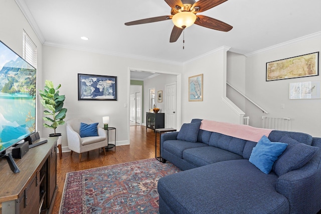 living room featuring crown molding, dark wood-type flooring, and ceiling fan