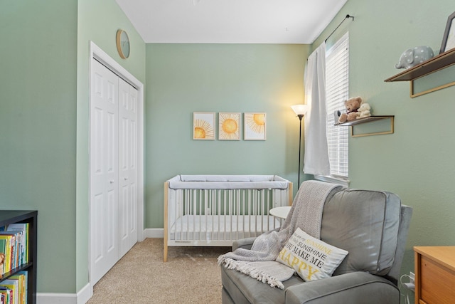 bedroom with a nursery area, a closet, and light carpet