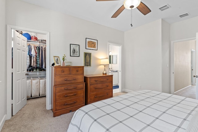 carpeted bedroom featuring a walk in closet, ceiling fan, and a closet