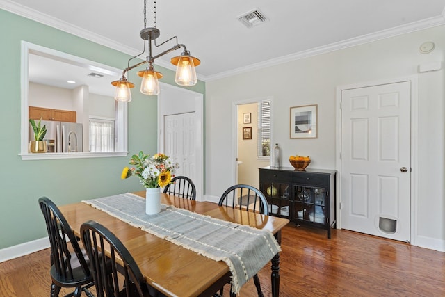 dining area featuring ornamental molding and dark hardwood / wood-style floors