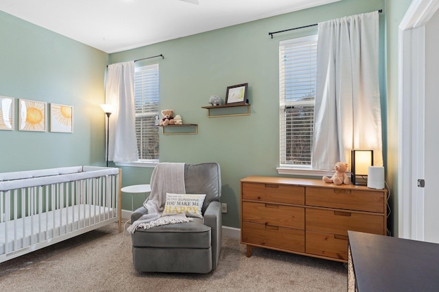 bedroom featuring multiple windows, light carpet, and a nursery area