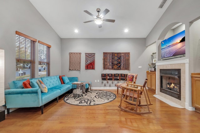 living room featuring ceiling fan, a fireplace, and light hardwood / wood-style floors