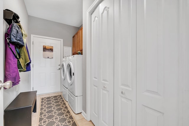 laundry room featuring cabinets, light tile patterned flooring, and washing machine and clothes dryer