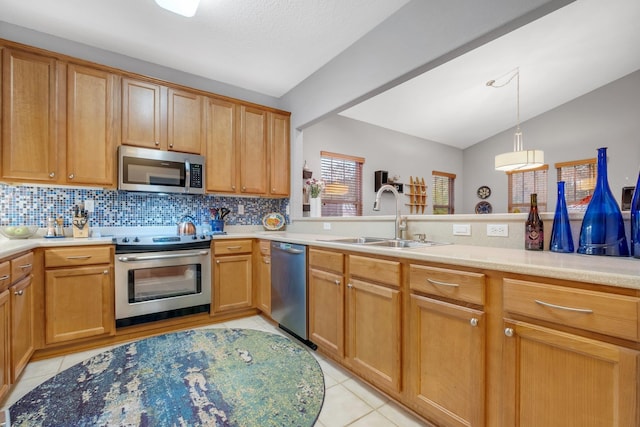 kitchen with pendant lighting, sink, backsplash, light tile patterned floors, and stainless steel appliances