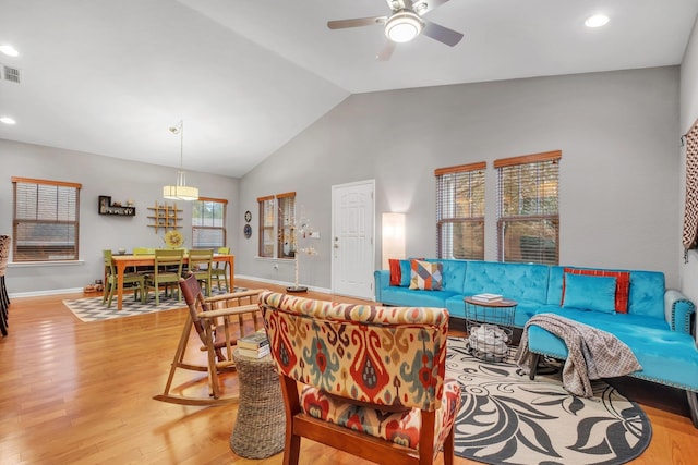 living room with vaulted ceiling, ceiling fan, and light hardwood / wood-style flooring