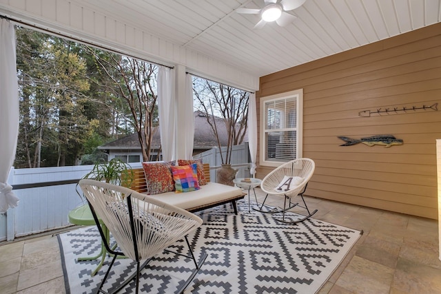 sunroom featuring wood ceiling and ceiling fan