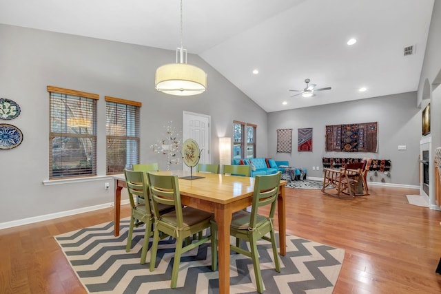 dining room featuring ceiling fan, high vaulted ceiling, and light hardwood / wood-style floors