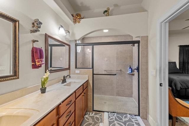 bathroom featuring a shower with shower door and vanity