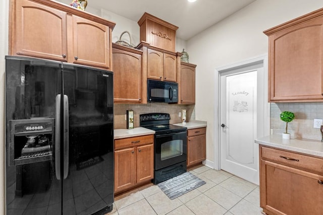 kitchen with light tile patterned flooring, black appliances, and tasteful backsplash