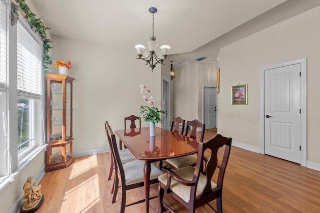 dining area featuring a wealth of natural light, light hardwood / wood-style flooring, and a notable chandelier