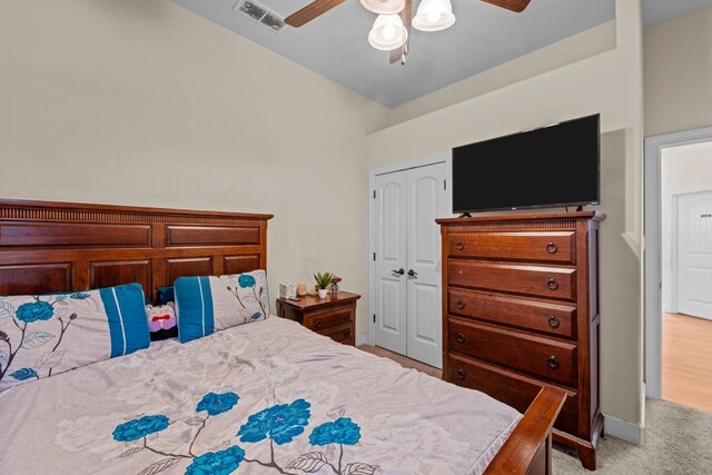 carpeted bedroom featuring ceiling fan and a closet